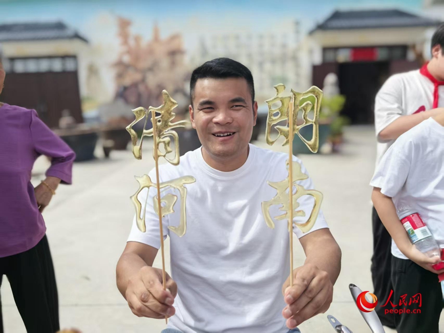 乡村大集上,摊主用麦芽糖做了“清朗河南”的糖画。人民网记者 王佩摄